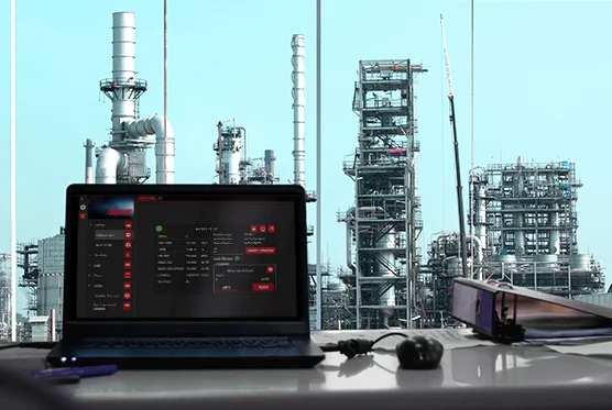 Image of a computer on a desk with a view of a facility in need of environmental monitroing