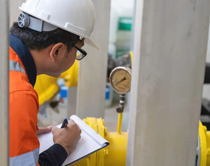 Photo of an engineer conducting leak testing in a boiler room